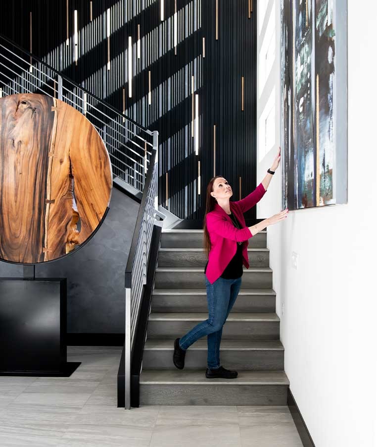Woman standing at the bottom of a set of stairs in a modern house